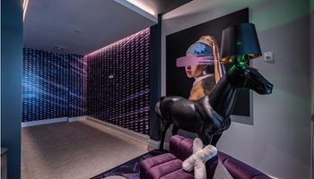 A living room with a horse statue and a purple couch